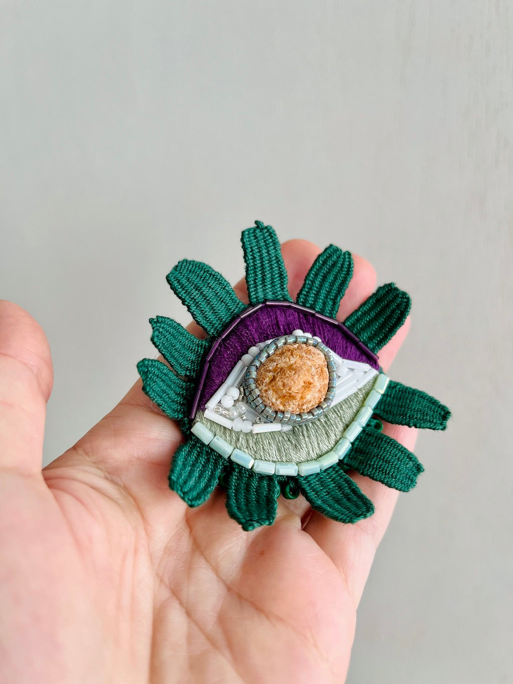 Hand-embroidered eye brooch with Croatian sea stone and Miyuki beads, handmade in Vienna