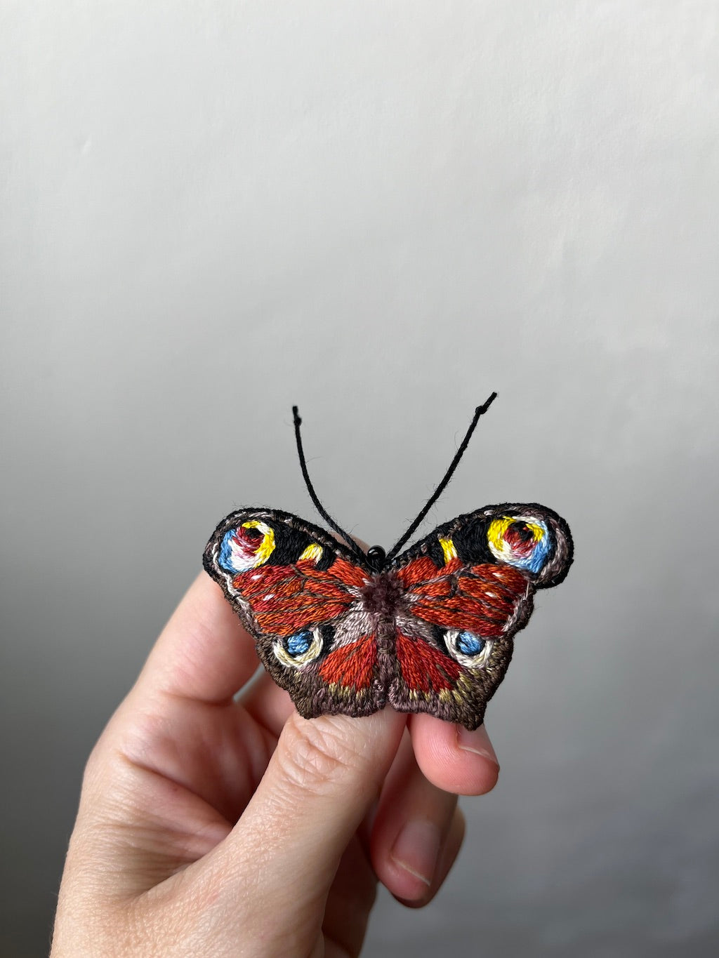 Hand-embroidered peacock butterfly brooch with glass beads, handmade in Vienna