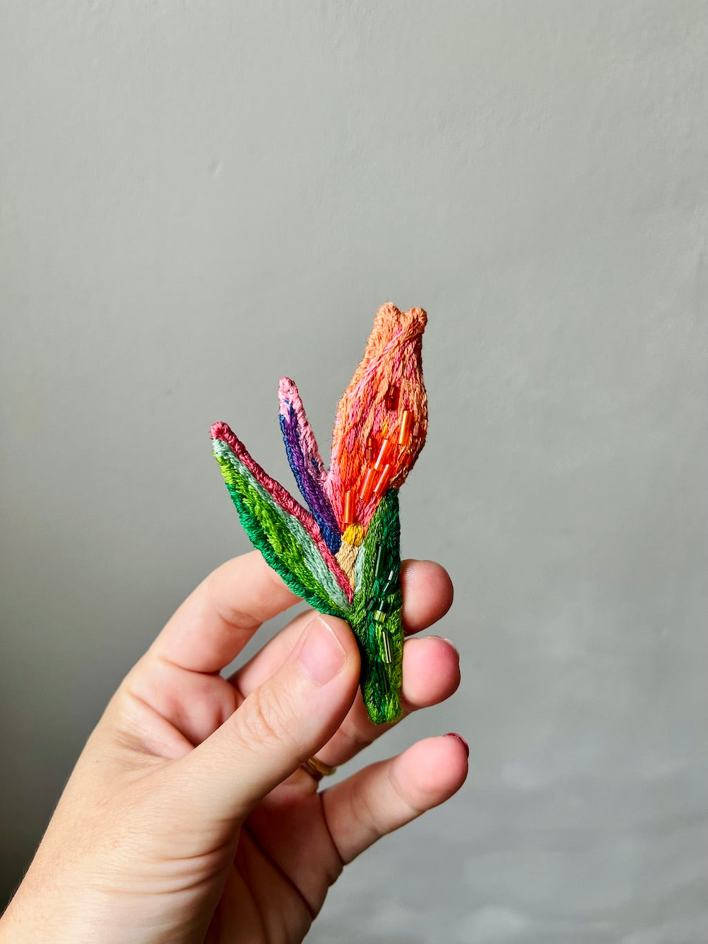 Hand-embroidered bird of paradise flower brooch with glass beads, handmade in Vienna